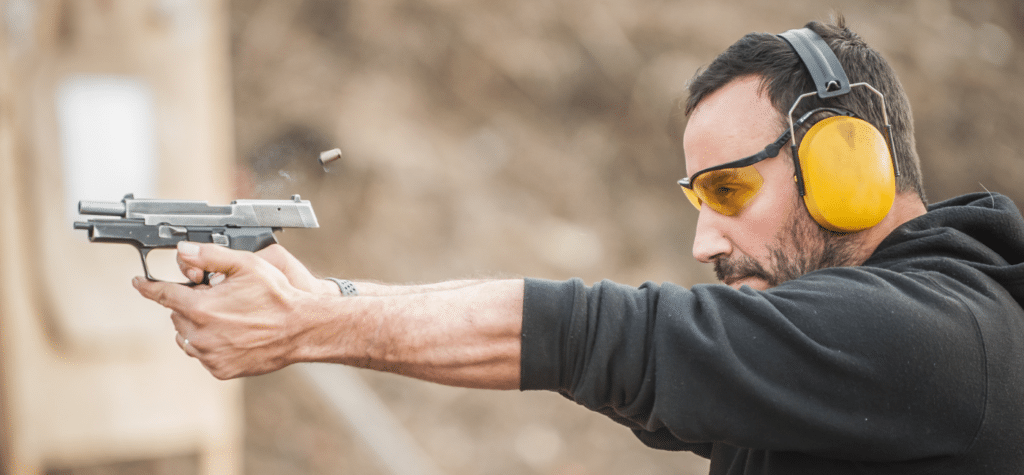 photo of man shooting pistol in a class that is full after marketing for trainers with tactical content marketing