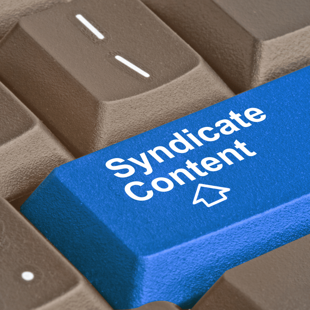 photo of keyboard with blue key that says syndicate content for content syndication and distribution