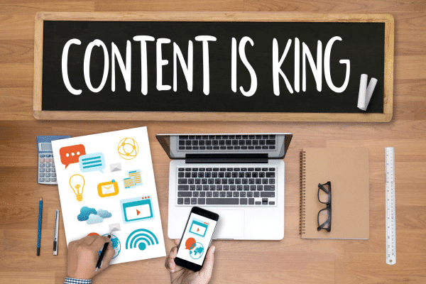 photo of desk with content is king sign showing content marketing vs digital marketing