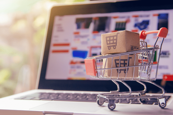 photo of laptop with a small shopping cart showing ecommerce seo strategies for conversions