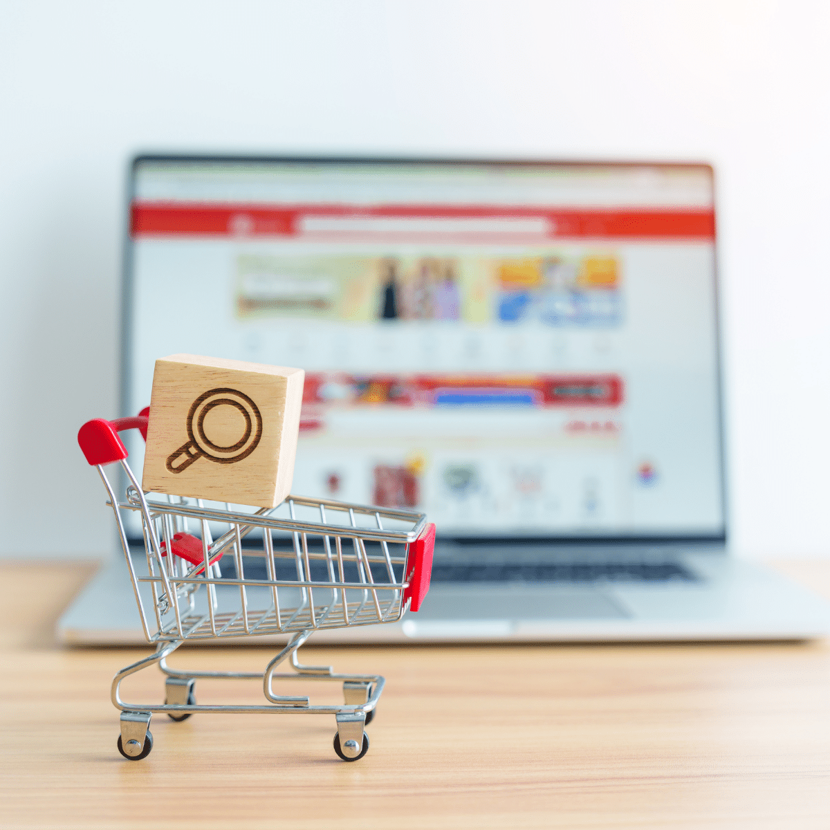 photo of laptop and little shopping cart showing how to optimize your ecommerce site for seo
